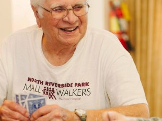 A man smiling and playing cards