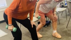 An instructor and resident work side by side in a strength training class at Cordia Senior Residence in Westmont