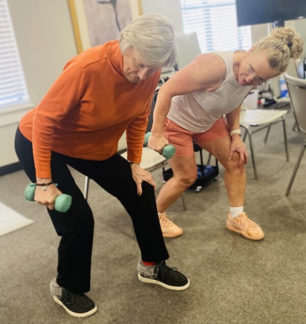 An instructor and resident work side by side in a strength training class at Cordia Senior Residence in Westmont